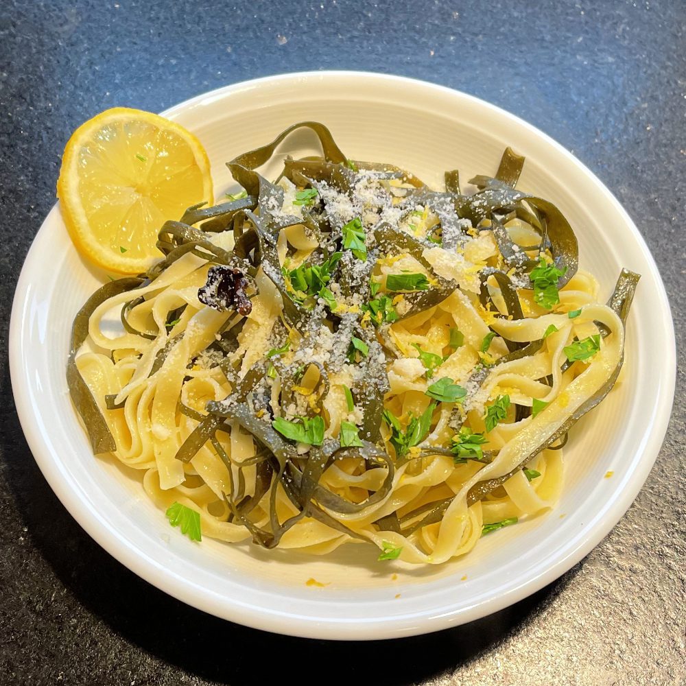 Ein Teller mit Pasta al limone mit Meeresspaghetti und Bandnudeln